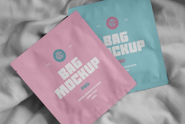 View from above, two cosmetic bag mockups in pastel pink and pastel blue colors lying on white bedding.