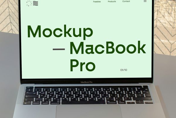Front view, open silver MacBook Pro mockup laying on the grey table.