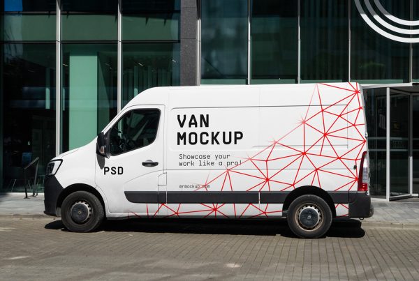 Front view, a white side van mockup with a red pattern and geometric typography design parked in front of the building.