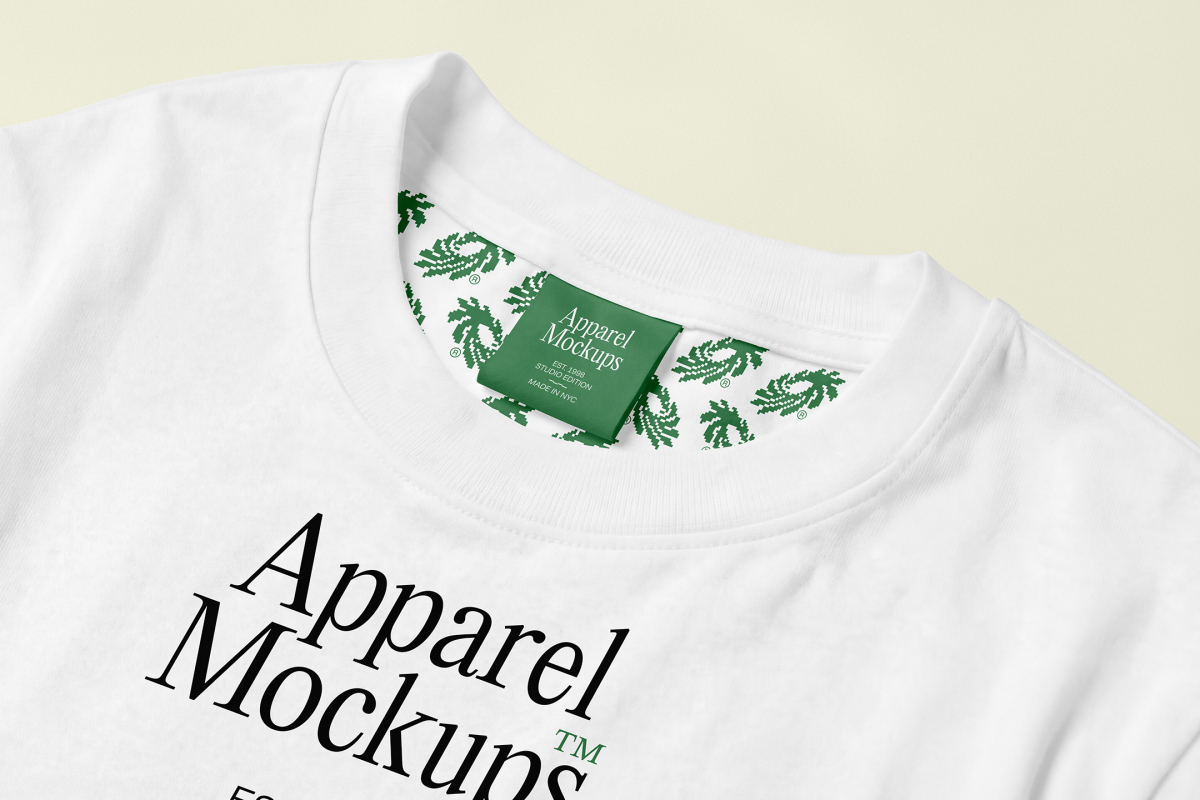 Lying white t-shirt mockup on a bright background with typography design in black and green color from studio apparel mockups product.