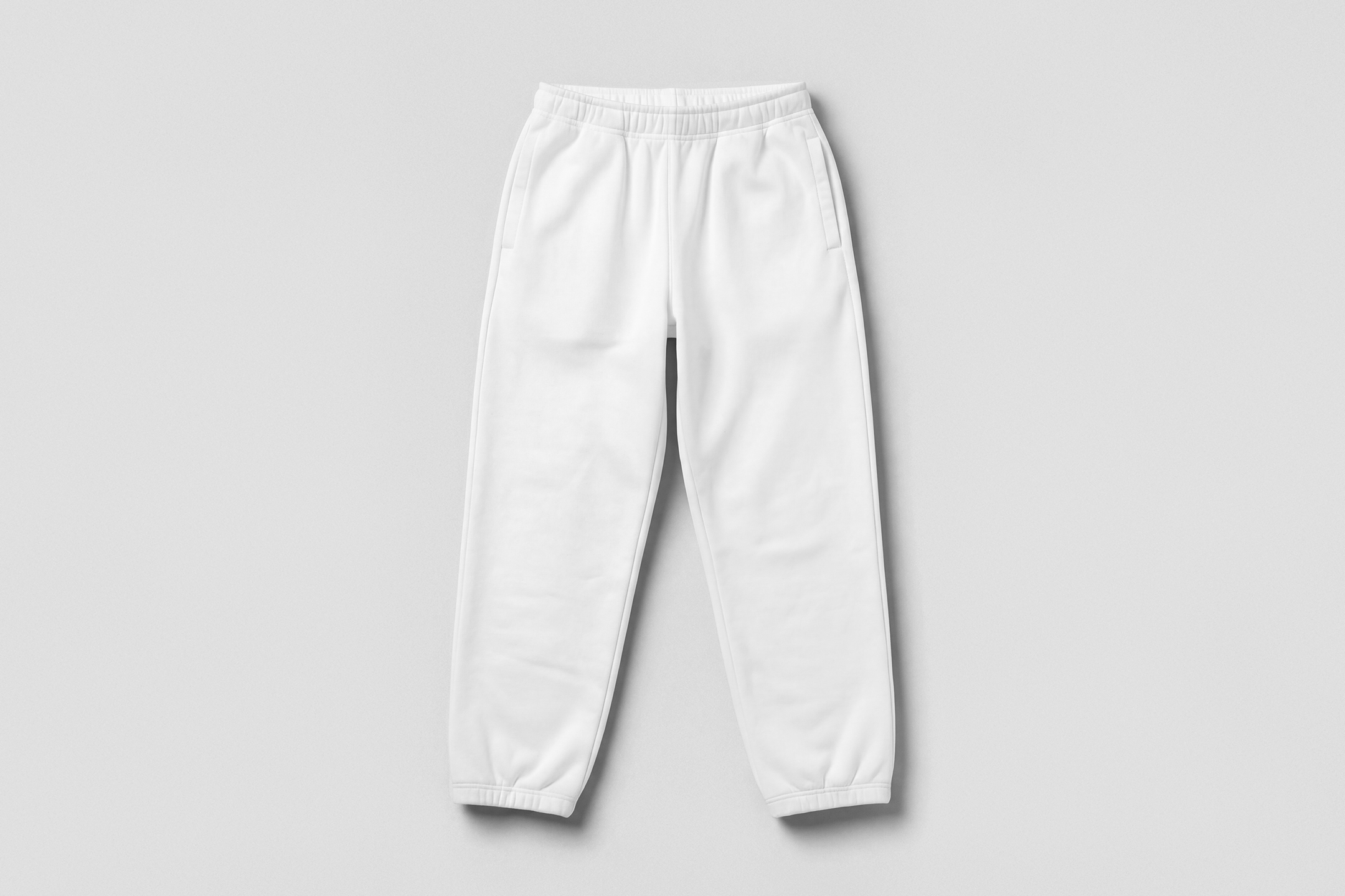 View from above, lying white sweatpants mockup on the white studio background color from the studio apparel mockups product.