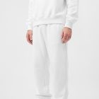 Front view of a standing male model wearing white sweatpants & a white sweatshirt mockup against a white studio background from the studio apparel mockups product.