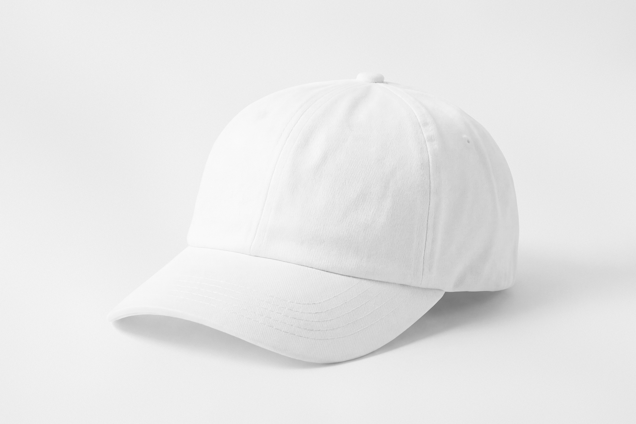 Front view, lying white baseball cap mockup on the white studio background from the studio apparel mockups product.