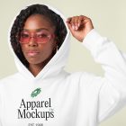 Front view of a Black female model wearing a white hoodie mockup standing against the bright studio background from studio apparel mockups product.