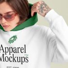 Front view of a female model wearing a white hoodie mockup standing against the bright studio background from the studio apparel mockups product.