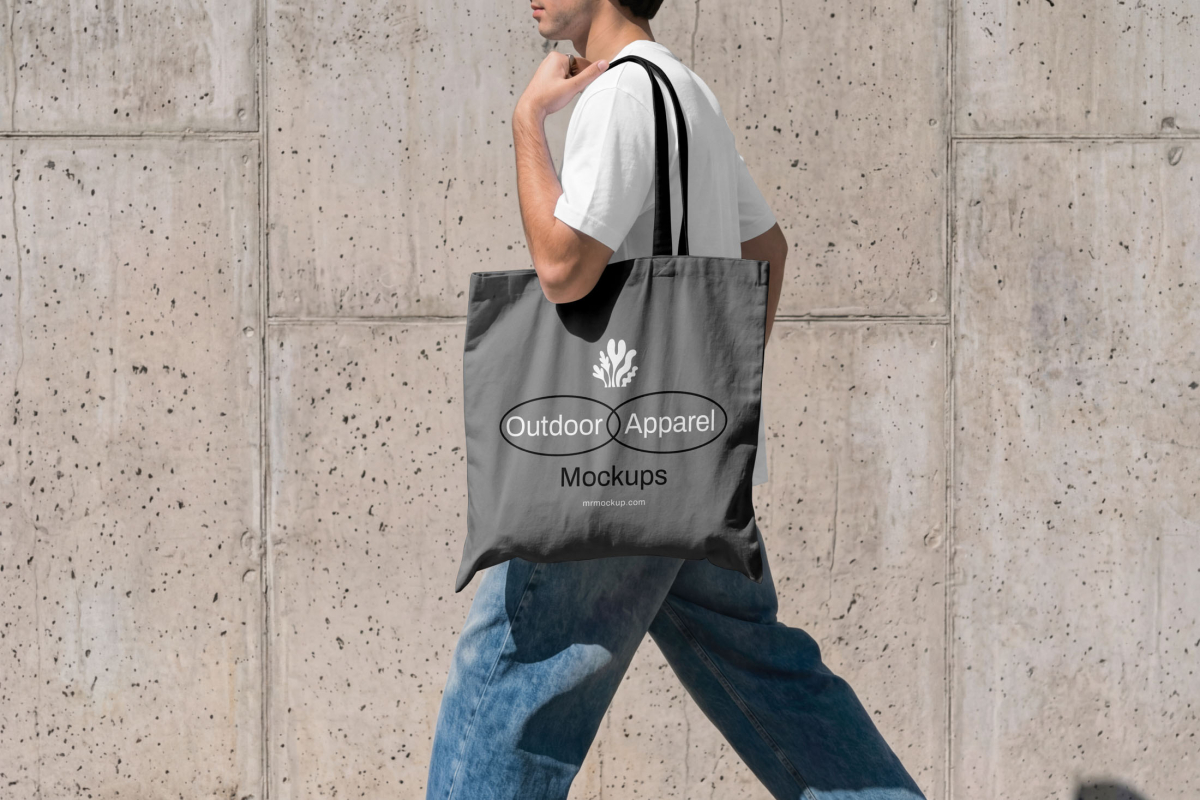 Front view, male model wearing a gray canvas bag mockup with a simple geometric typography logo from the Outdoor Apparel Mockups Vol.3 product.