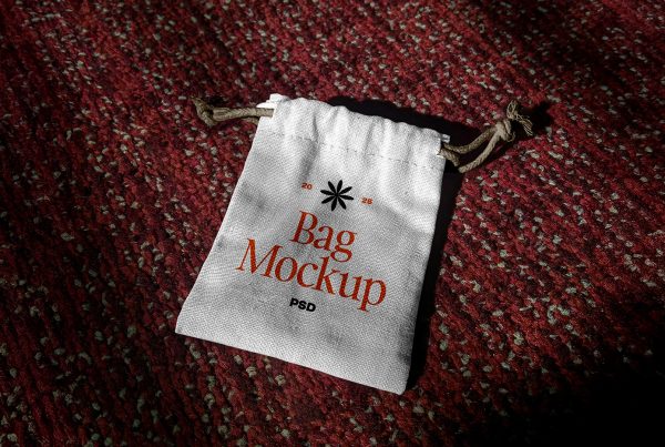 View from above a small white canvas bag mockup with typography design lying on the red carpet.