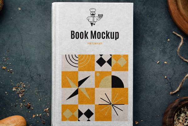 View from above a white recipe book mockup with black and yellow graphics lying on the kitchen wall.