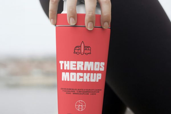 Front view of a red thermos mockup with white and black typography design held by a woman's hand.