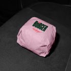 A burger wrapped in pink paper branded with a dark green "BÜRGER" logo and red "Food for you!" text, resting on a dark, textured vehicle seat.