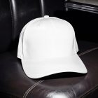 A plain white baseball cap placed on a dark, tufted leather booth seat inside a diner or restaurant.