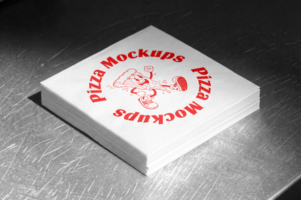 A neat stack of white, square paper napkins sitting on a scratched metal surface. The top napkin is printed with a red circular "Pizza Mockups" logo and a cartoon illustration of a running pizza slice.