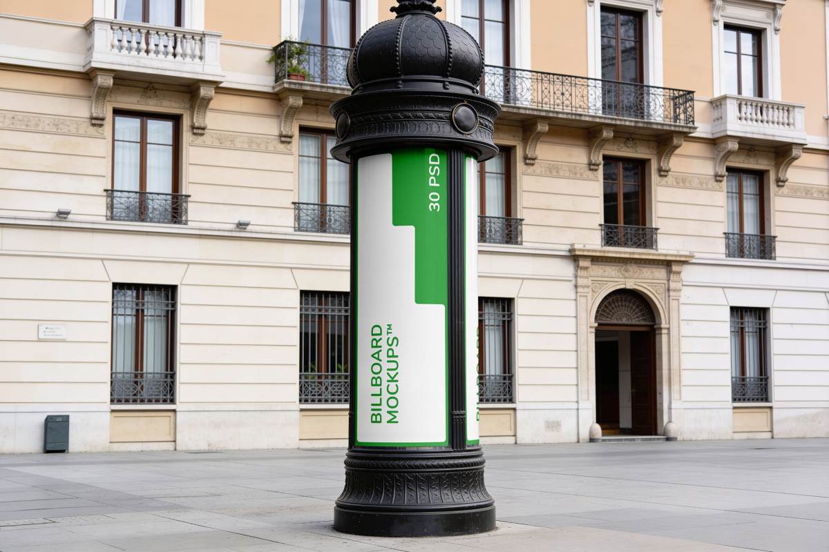 Classic black metal advertising column standing on a paved European city square in front of historic apartment buildings.