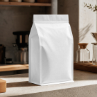 A blank white paper coffee bag standing on a counter next to an espresso machine portafilter and a glass pour-over dripper set.