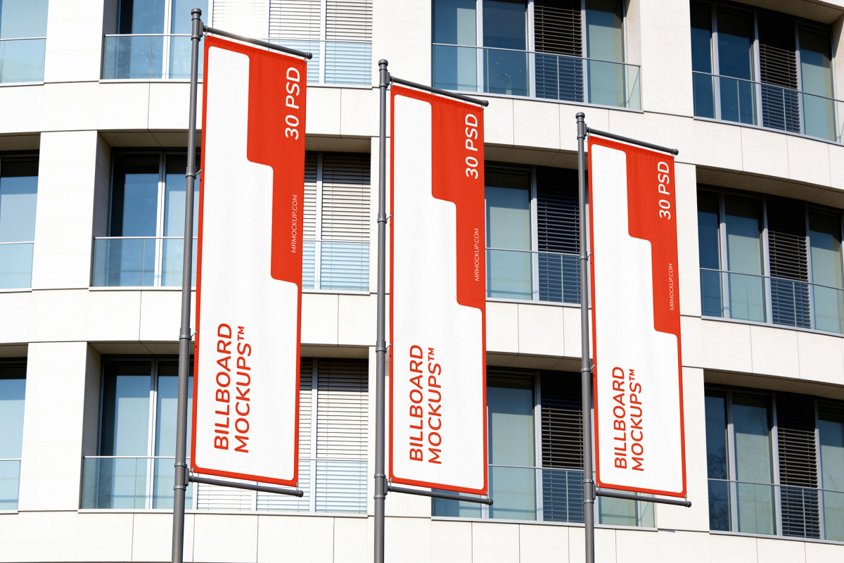 Three vertical outdoor advertising banners on metal poles lined up in front of a modern white building.