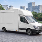 White Mercedes Sprinter food truck mockup with closed hatch parked on a paved plaza near modern skyscrapers.