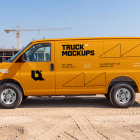 Side view of a bright yellow commercial cargo van parked at a dusty construction site.