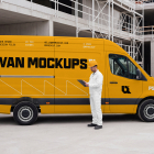 Side view of a yellow panel van with a construction worker in white overalls standing alongside holding a clipboard.