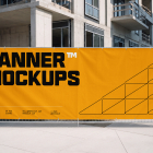 Large yellow promotional banner attached to a temporary wire mesh fence at a construction site.