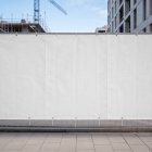 Large blank white banner mounted on a temporary metal construction site fence.