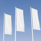 Three white vertical promotional flags flying on flagpoles against a clear blue sky.