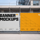 Row of alternating white and yellow printed banners fixed to scaffolding along a site barrier.