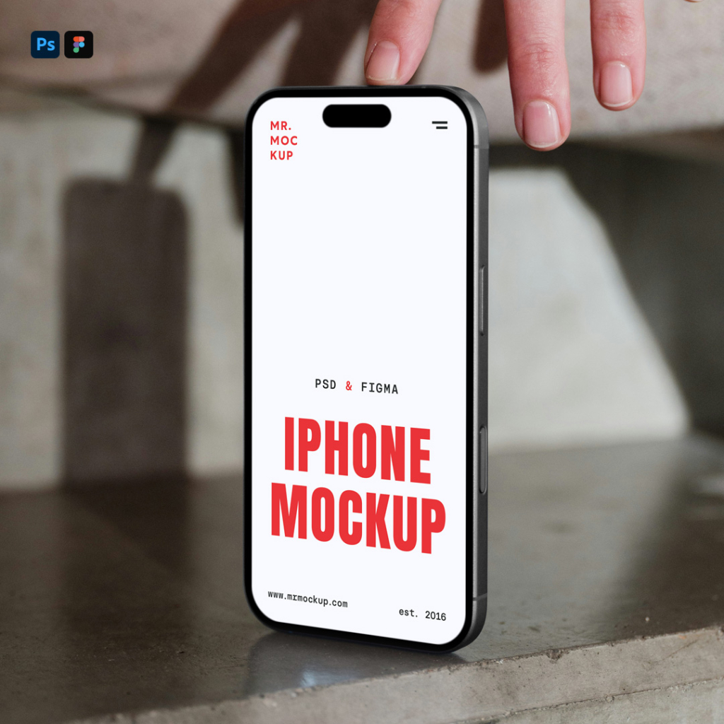 A close-up front-view shot of an iPhone featuring a blank, bright white screen with a Dynamic Island notch. The phone is supported upright against a textured grey concrete surface, with a person's fingers lightly holding the top edge, creating soft ambient shadows around the device. Free Front View Mobile Mockup