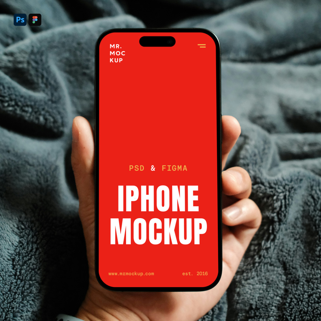 A hand holds a modern smartphone with a blank white screen, likely an iPhone with a dynamic island notch, against a backdrop of a soft, textured dark grey blanket. Free Hand Holding by iPhone PSD Mockup