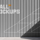 Corrugated grey metal wall paneling with line graphics under direct sunlight and shadow.