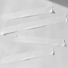 Four strips of white masking tape are applied horizontally to a lightly textured wall surface.