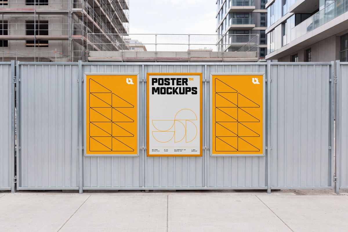 Three framed yellow and white promotional posters mounted on a metal construction site fence.