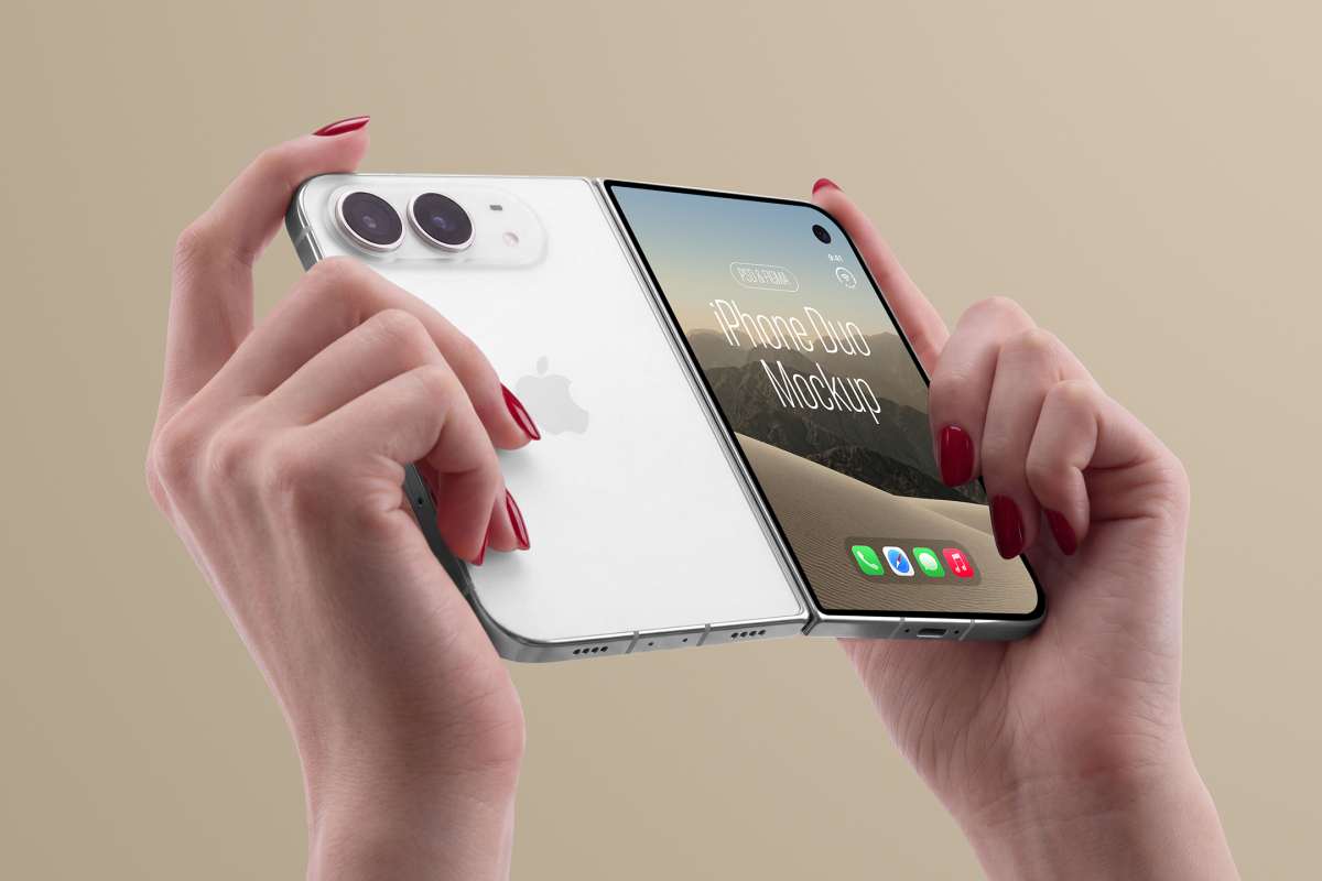 Hands holding a silver partially folded smartphone from the back, showing the white rear case, camera module, and screen displaying a desert landscape.