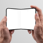 Two hands holding an open foldable smartphone with a blank white inner display against a light gray studio background.