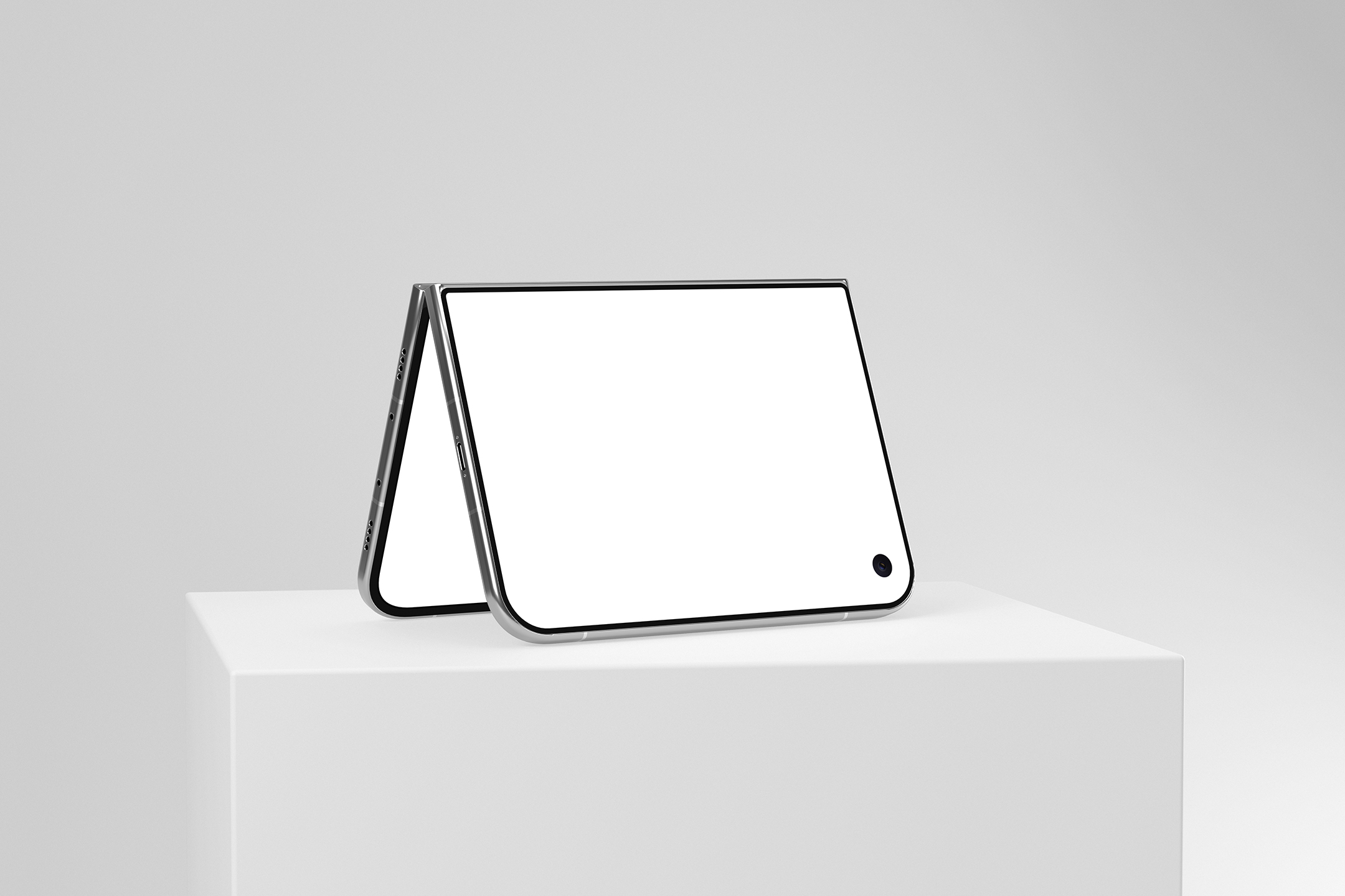 Foldable smartphone standing in tent mode on a white square pedestal, showing its blank display on a minimalist light gray background.